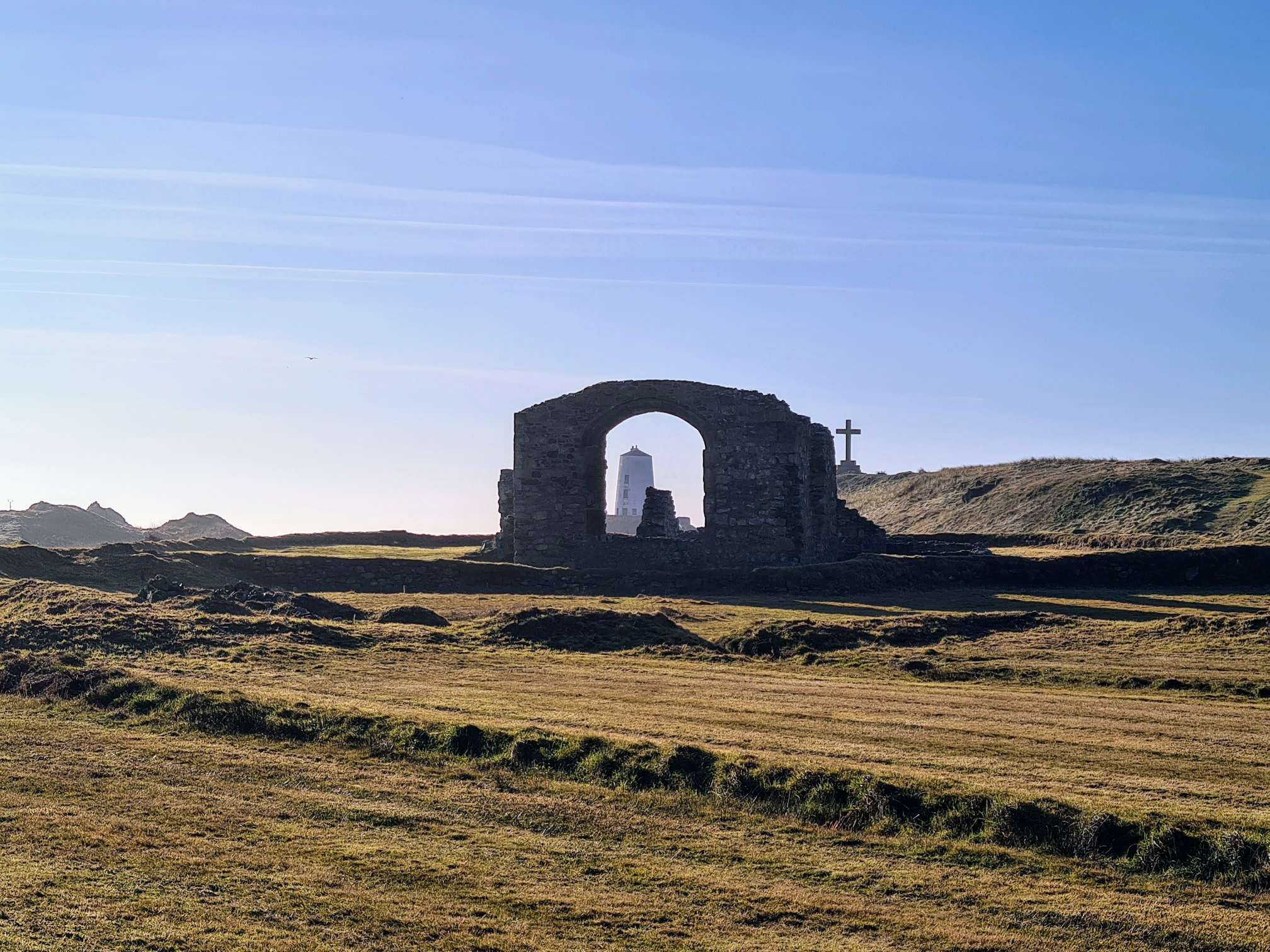 A picture showing the ancient chapel, lighthouse and holy cross together on Llanddwyn Island